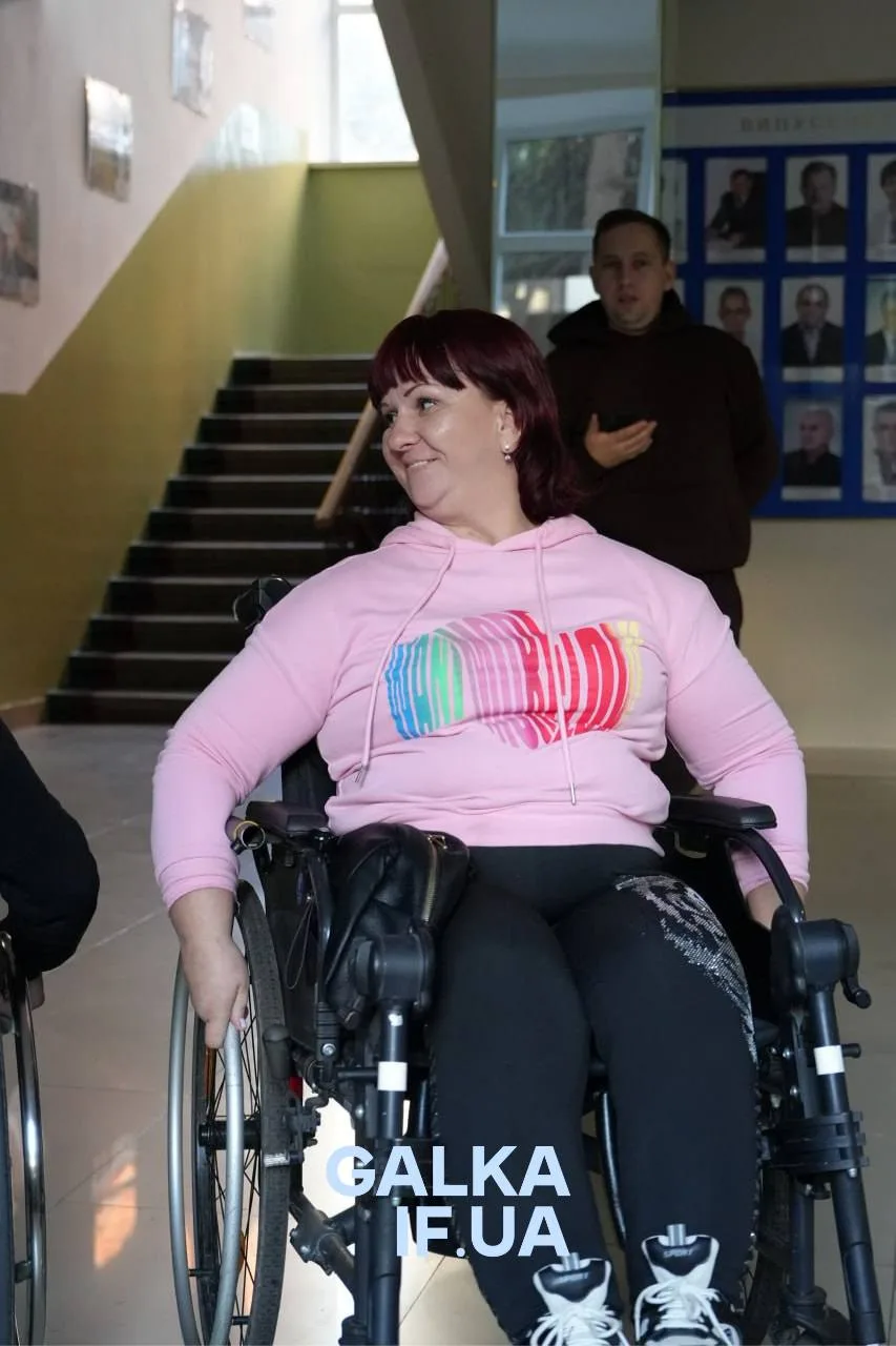 Жінка у візку усміхається в приміщенні