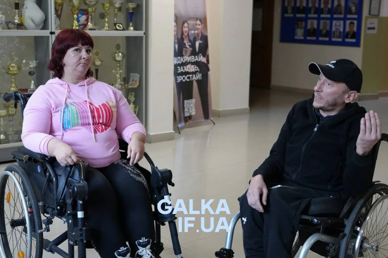 Двоє людей на інвалідних візках спілкуються в холі