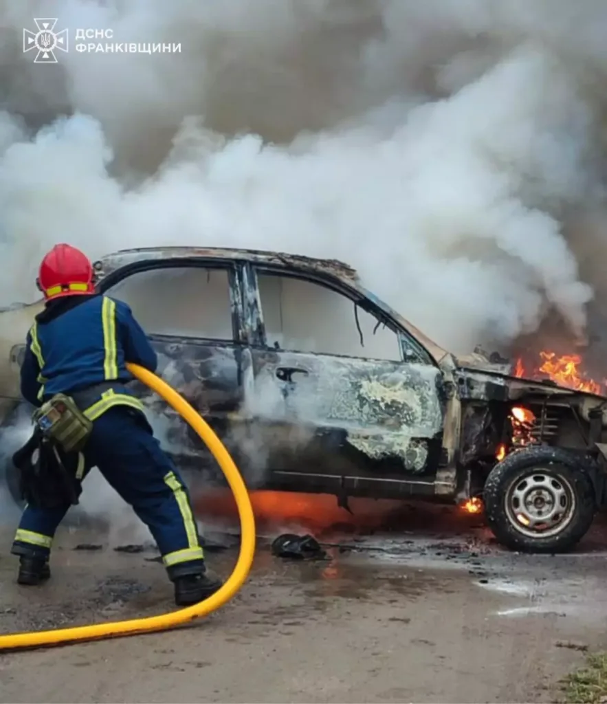 Пожежник гасить палаючий автомобіль