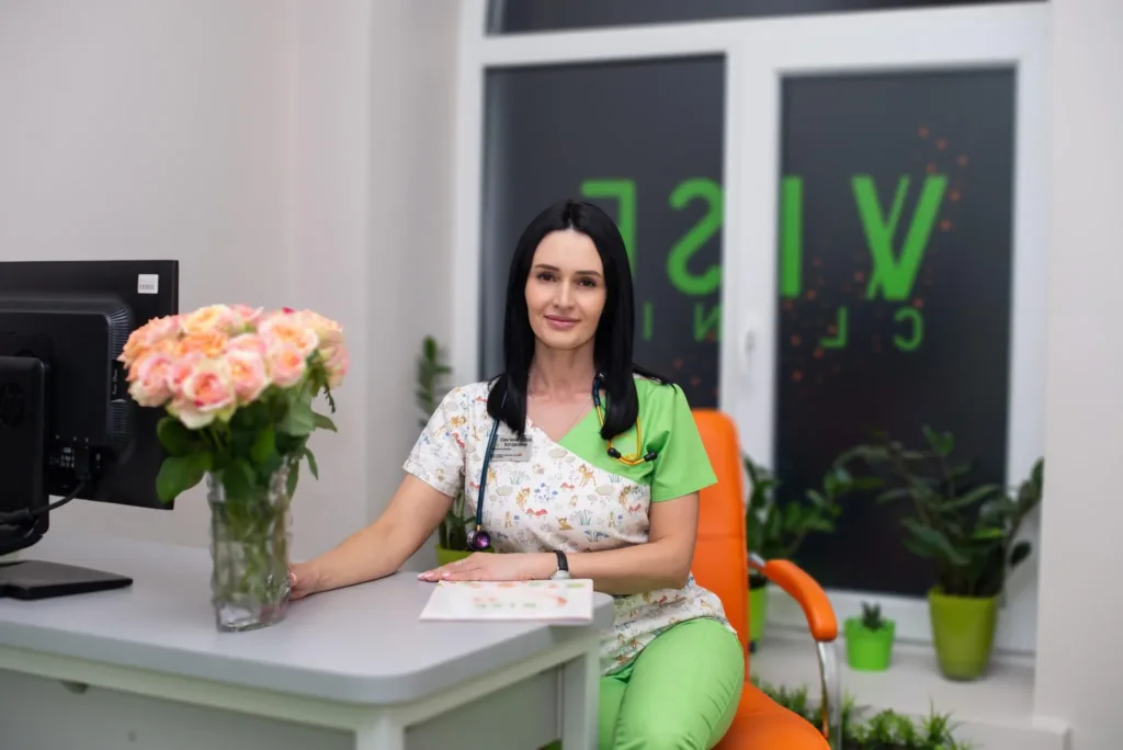 Жінка-медик у клініці сидить за столом