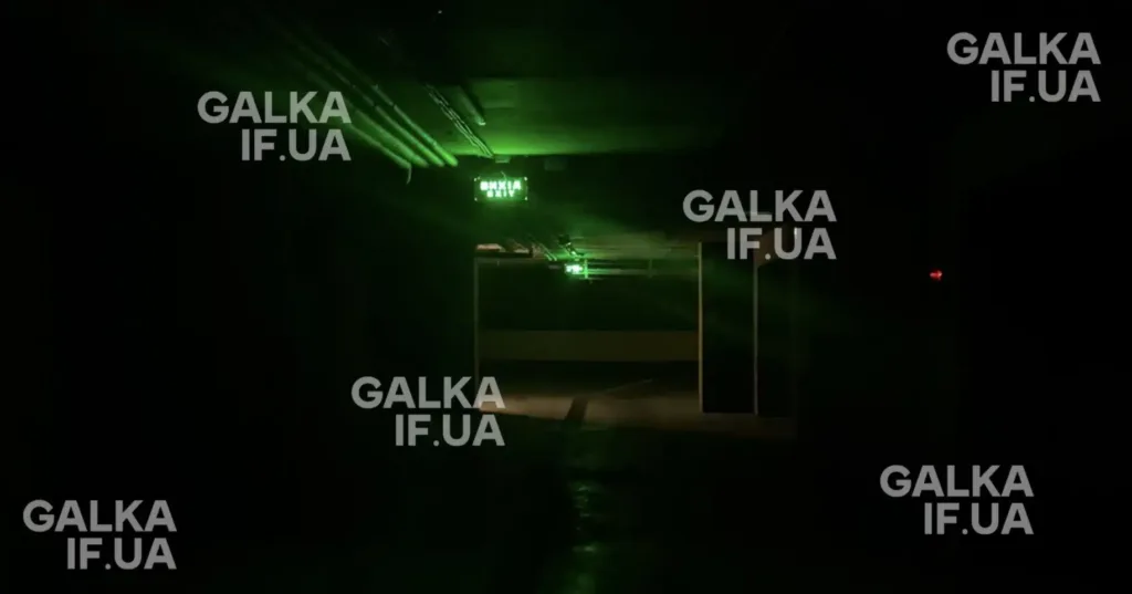 Темний коридор з зеленим аварійним виходом