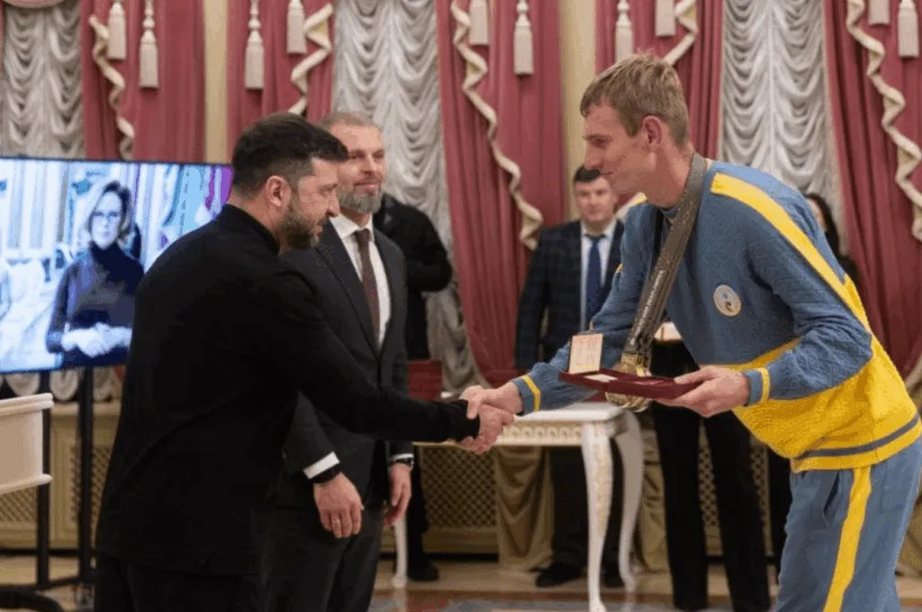 Вручення нагороди спортсмену у жовто-блакитному костюмі