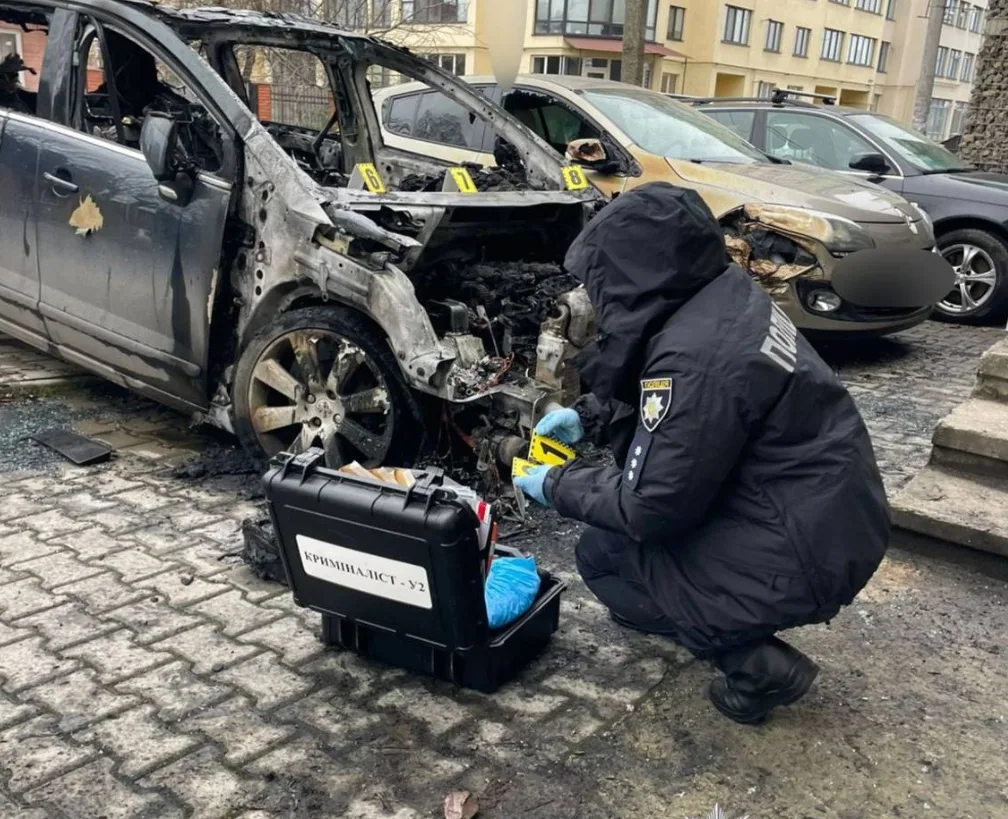 Криміналіст досліджує згорілий автомобіль після пожежі