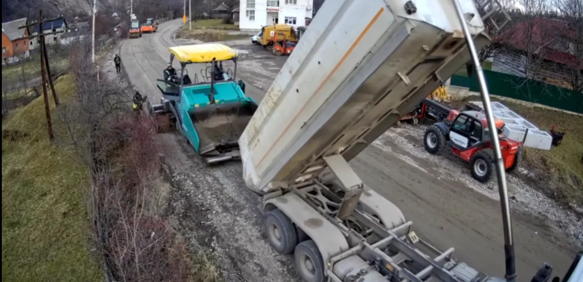 Ремонт дороги з асфальтоукладальником і вантажівкою