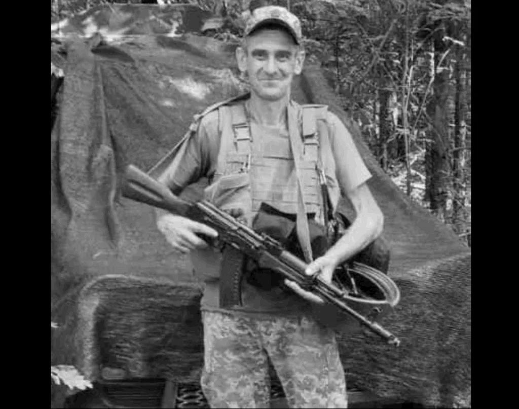 Військовий стоїть із гвинтівкою у лісі