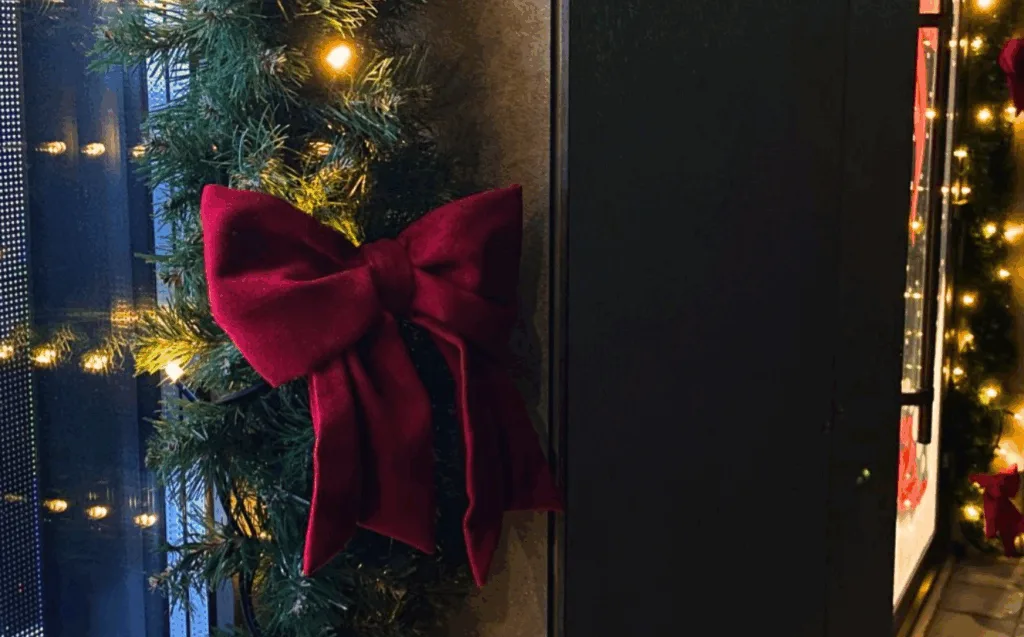 Різдвяний вінок із червоною стрічкою та вогниками