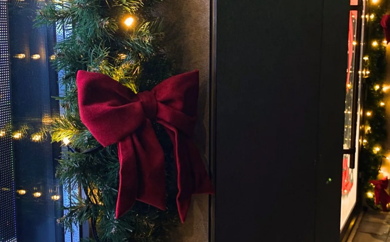 Різдвяний вінок із червоною стрічкою та вогниками