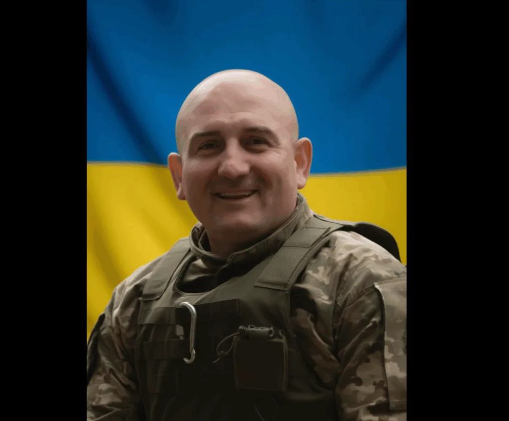 Український військовий перед прапором України