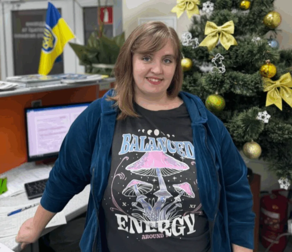 Жінка біля новорічної ялинки в офісі