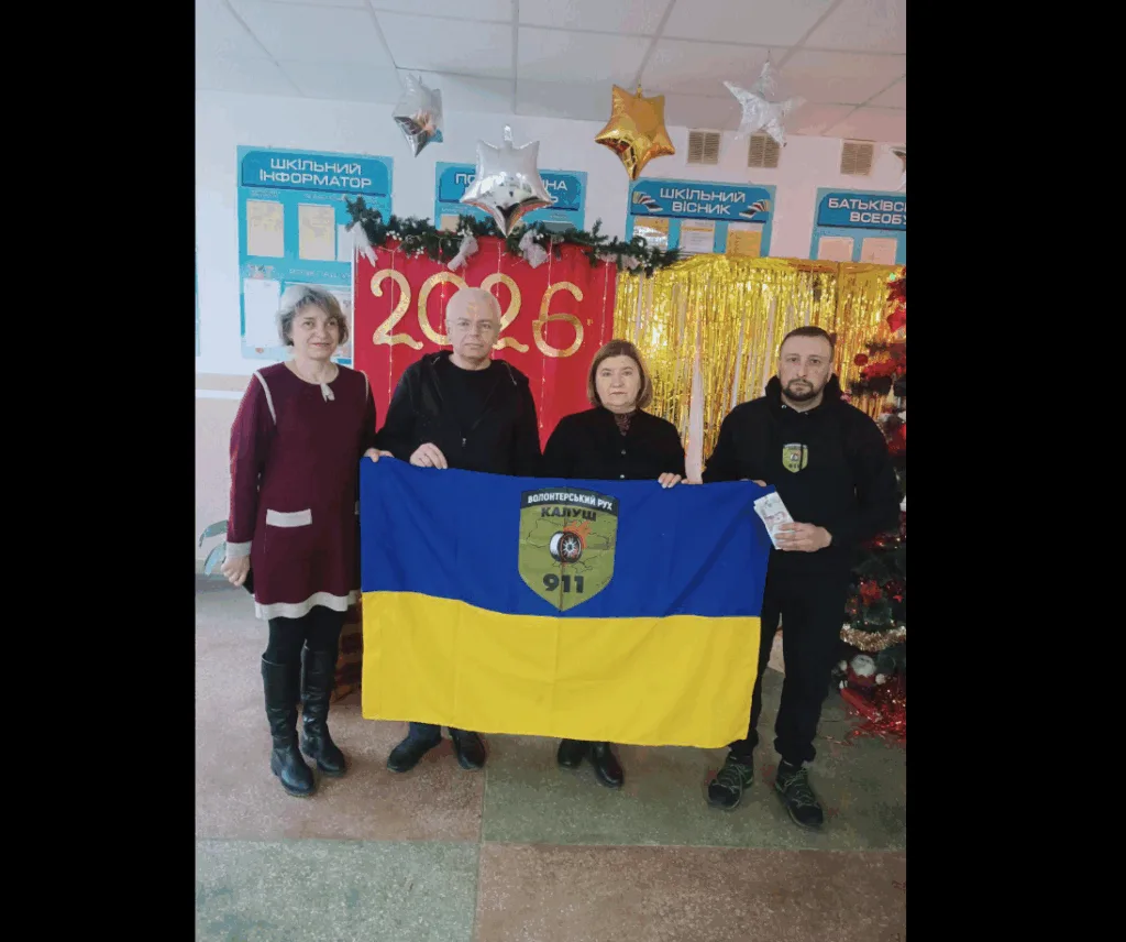 Волонтери з українським прапором у святковій залі