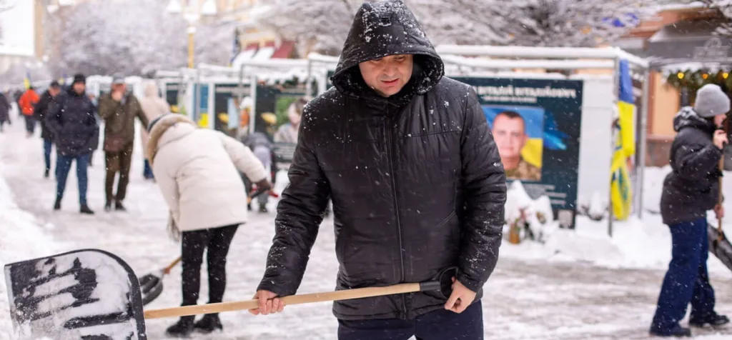 Люди розчищають сніг на міській вулиці взимку