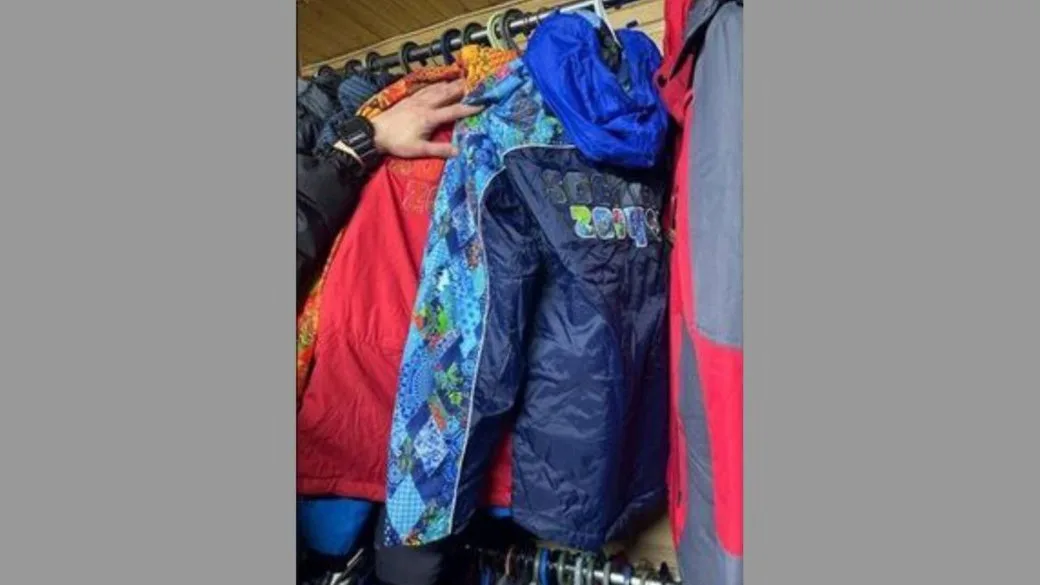 Кольорові куртки висять на вішалках у шафі