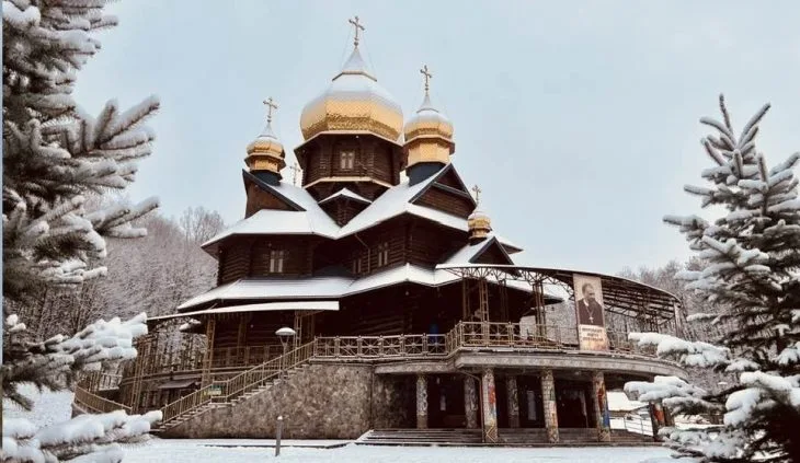 Дерев'яна церква взимку з золотими куполами