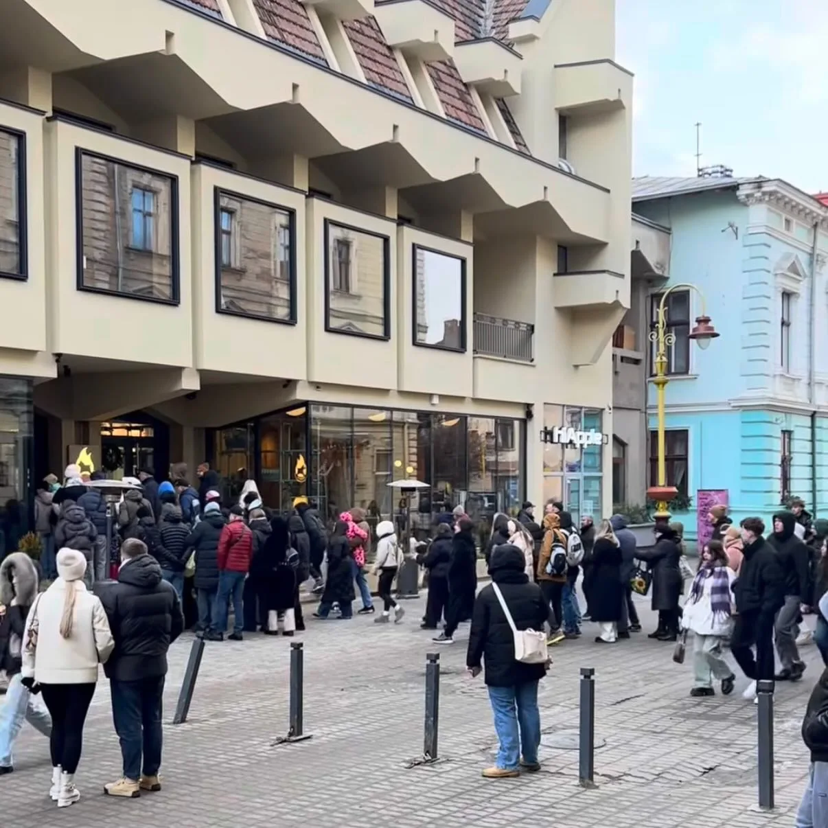 Черга людей біля сучасної будівлі в центрі міста