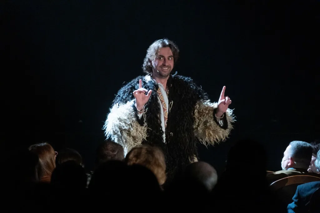 Актор виступає на сцені перед глядачами