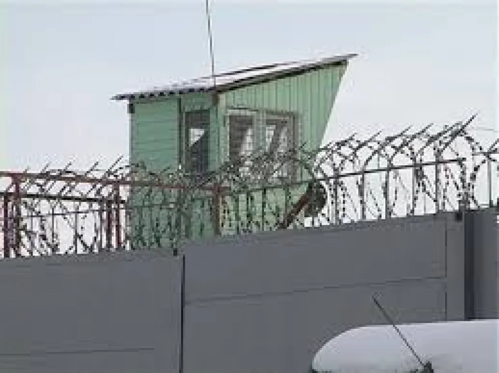 Вежа охорони з колючим дротом на паркані