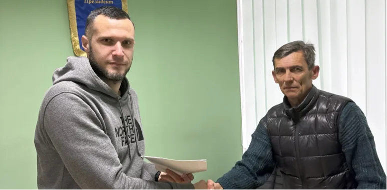 Двоє чоловіків потискають руки в офісі