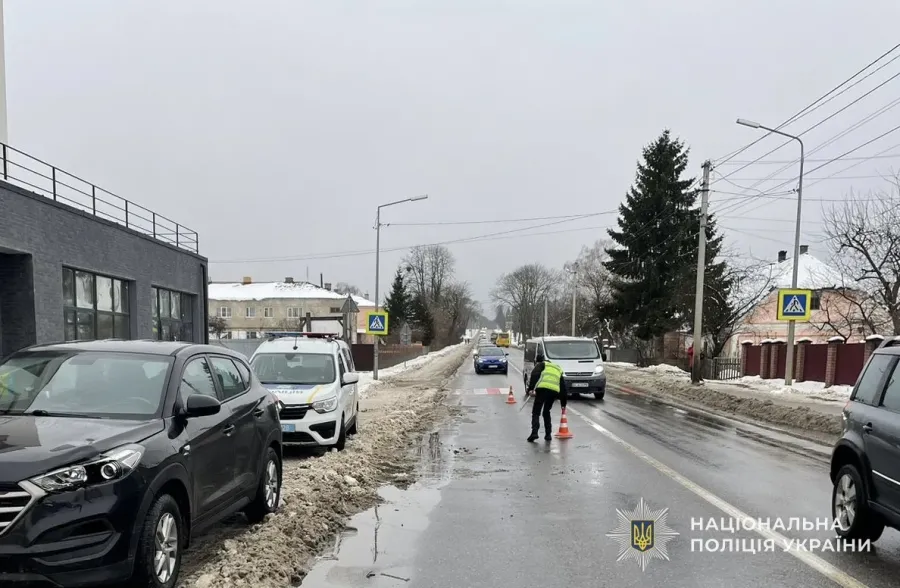 Поліцейський перекриває зимову дорогу конусами