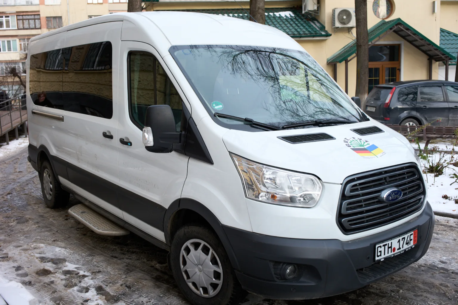 Білий фургон стоїть на засніженій вулиці