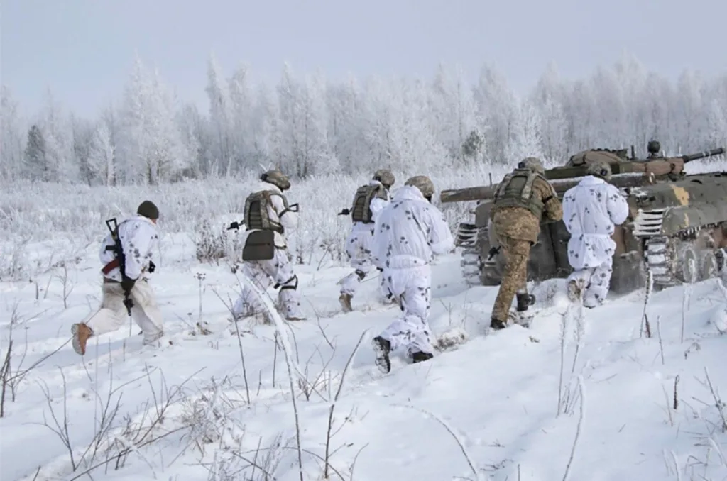 Військові у зимовому камуфляжі поруч із танком