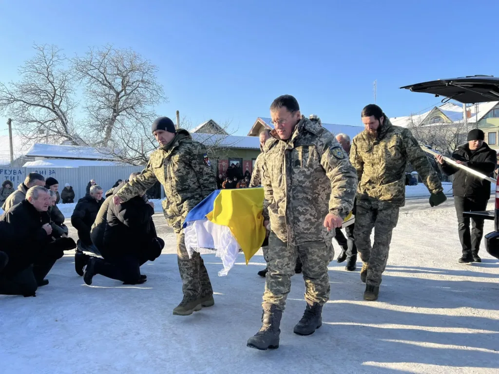 Військові несуть труну з українським прапором