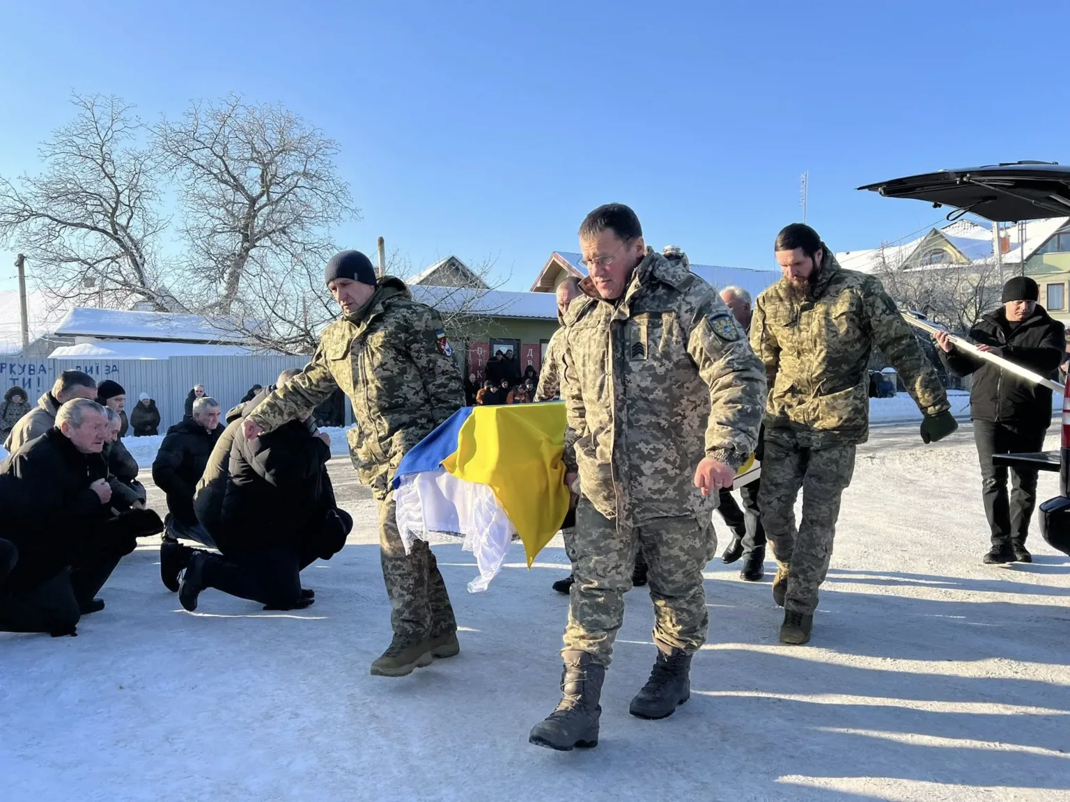 Військові несуть труну з українським прапором