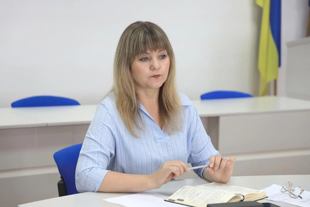 Жінка на нараді з нотатником у класі