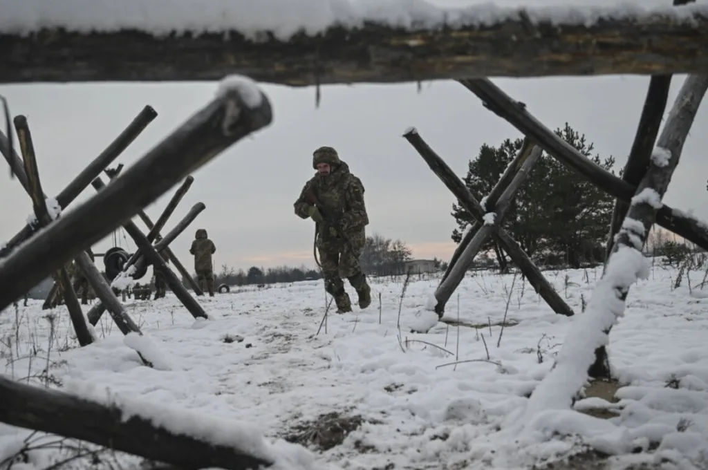 Військові йдуть через засніжене поле з укріпленнями
