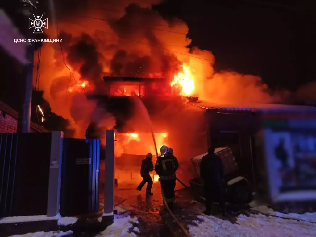 Пожежники гасять вогонь у будівлі вночі