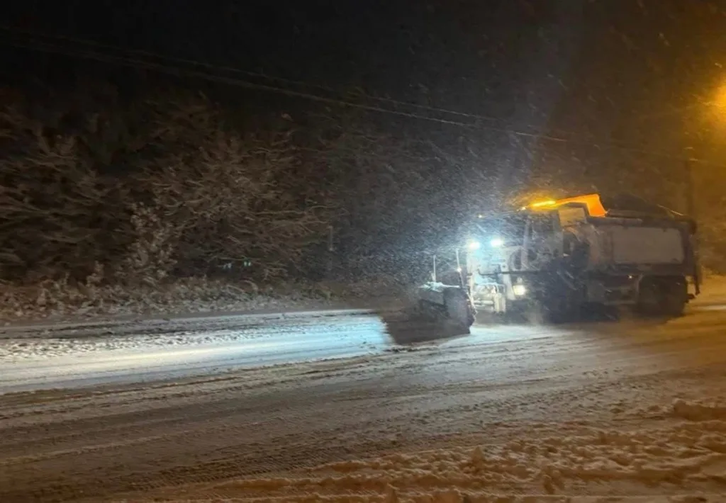 Снігоприбиральна машина чистить засніжену дорогу вночі
