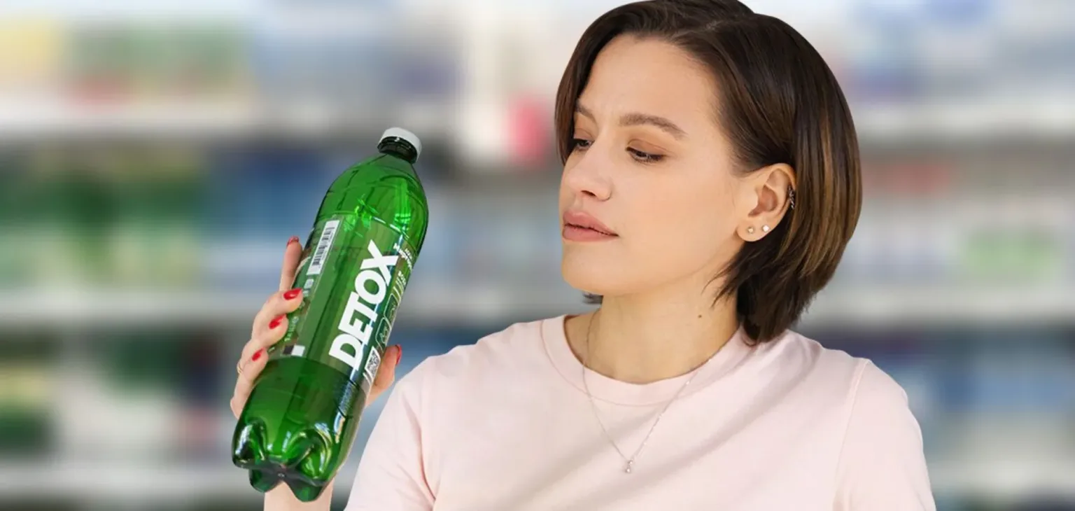 Жінка тримає пляшку напою Detox у магазині