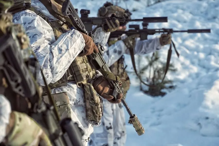 Військові у зимовому камуфляжі з гвинтівками на снігу
