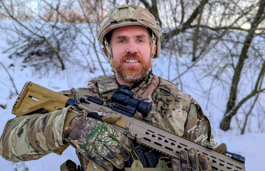 Військовий у камуфляжі з гвинтівкою на снігу