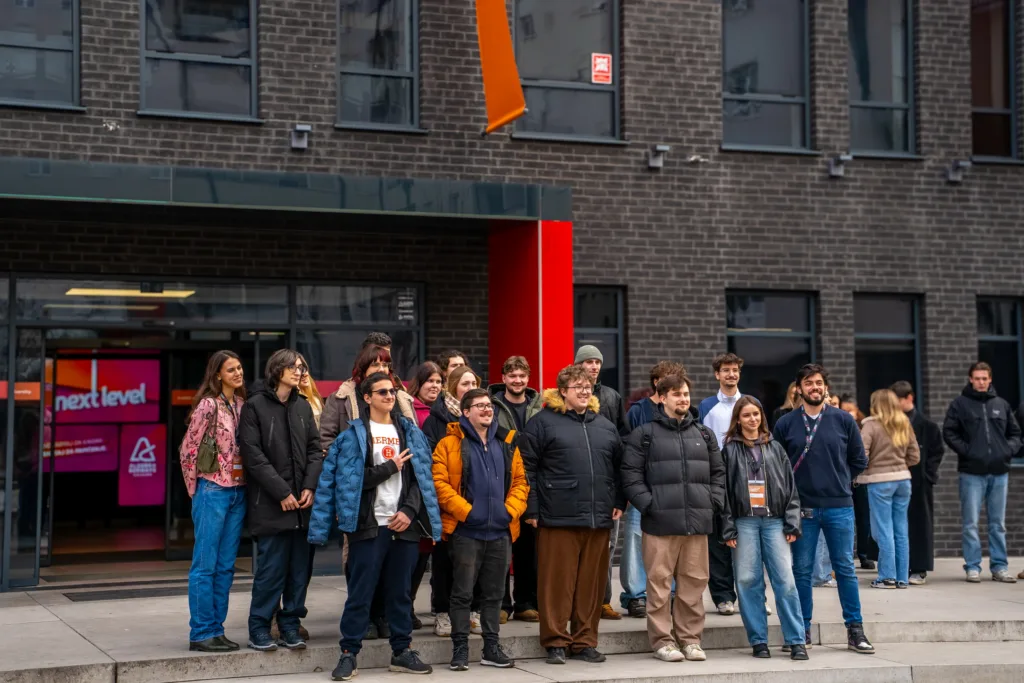 Група людей стоїть перед сучасною будівлею