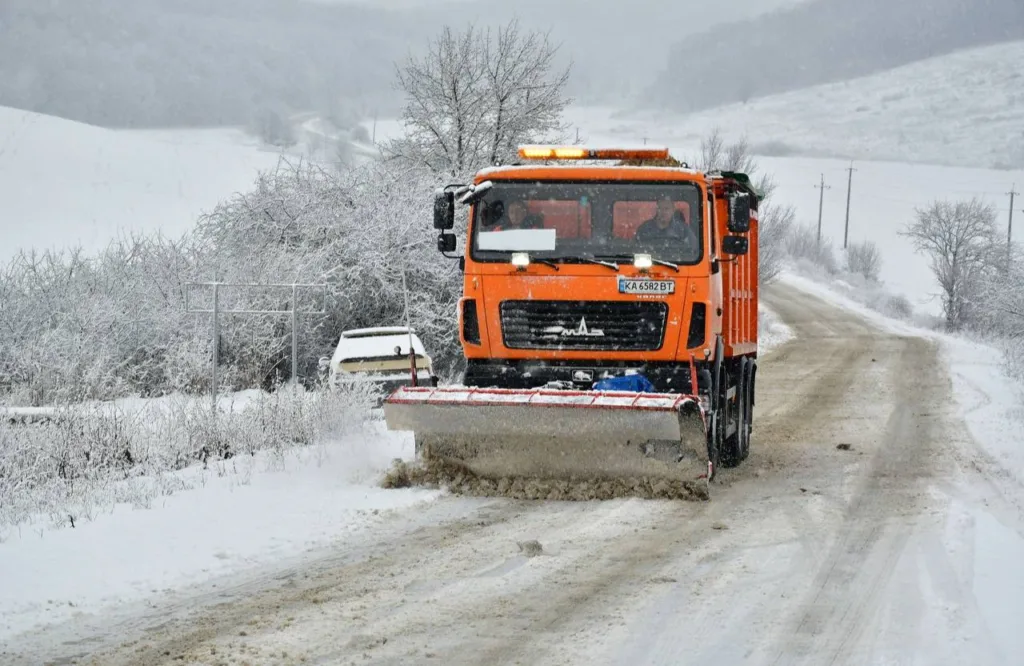 Снігоочисна машина очищає зимову дорогу
