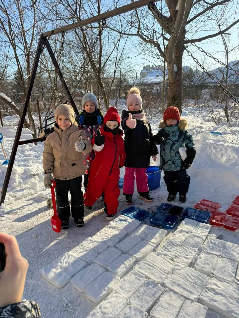 Діти граються на снігу взимку з лопатами