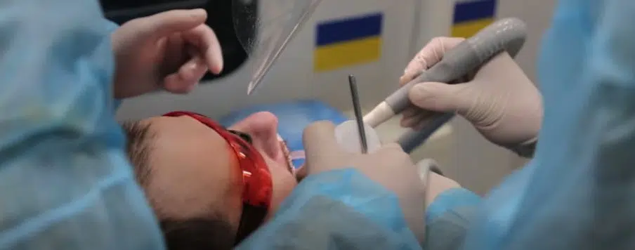 Стоматолог лікує пацієнта у клініці України