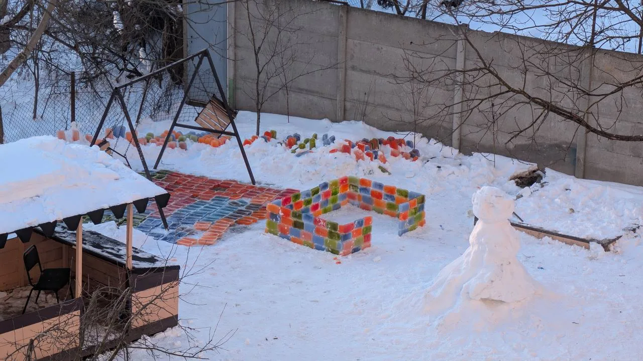 Дитячий майданчик із кольоровими крижаними блоками взимку