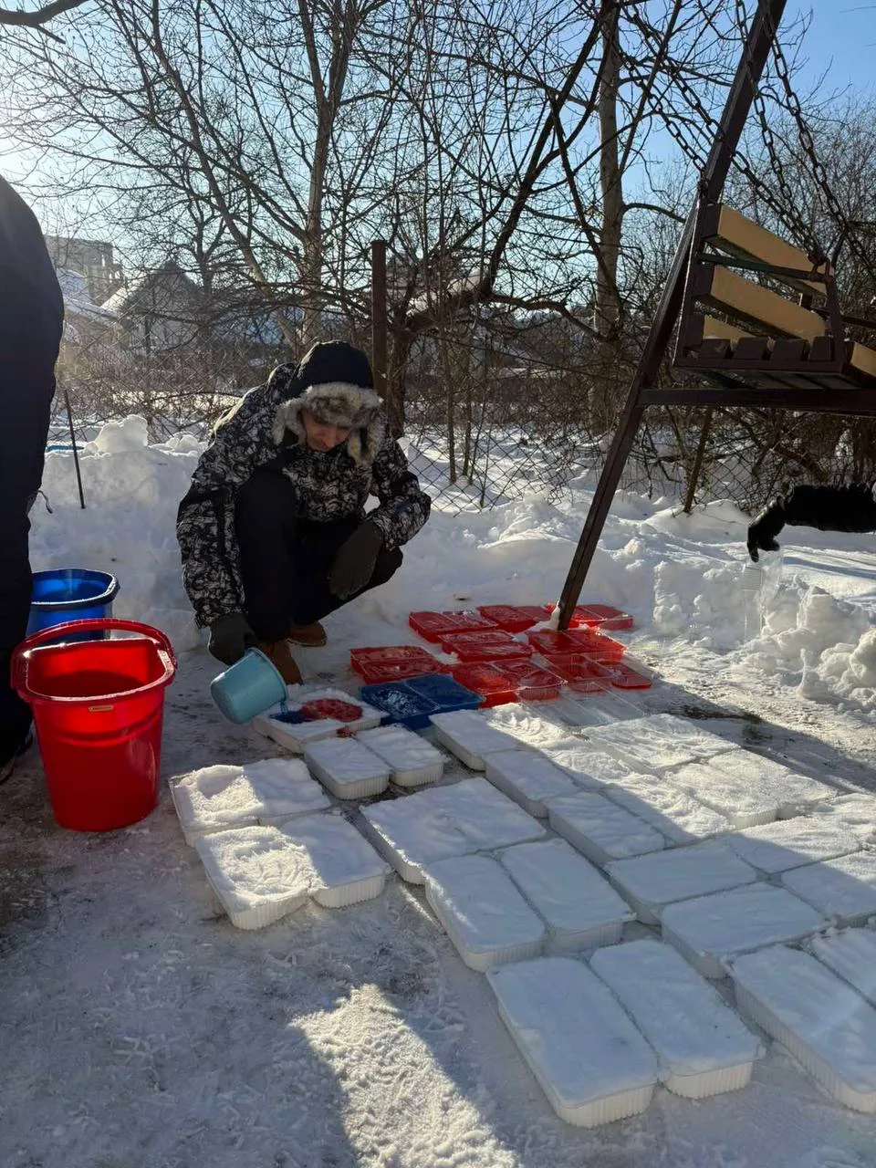 Людина робить снігові блоки у зимовому дворі