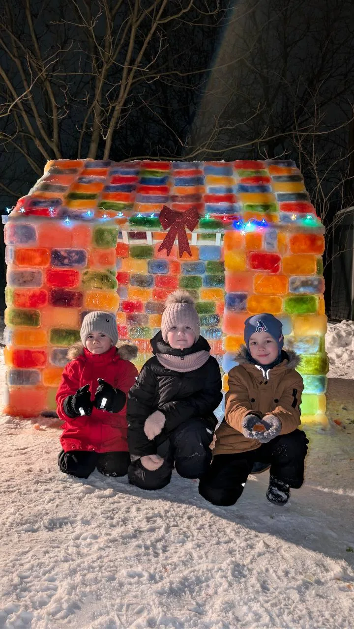 Діти перед різнокольоровим льодовим будиночком взимку