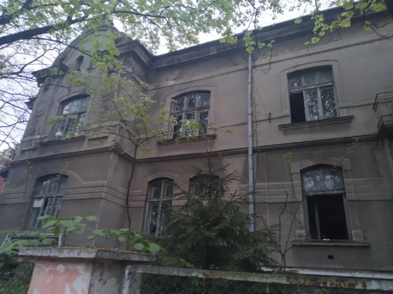 Стара занедбана будівля серед дерев