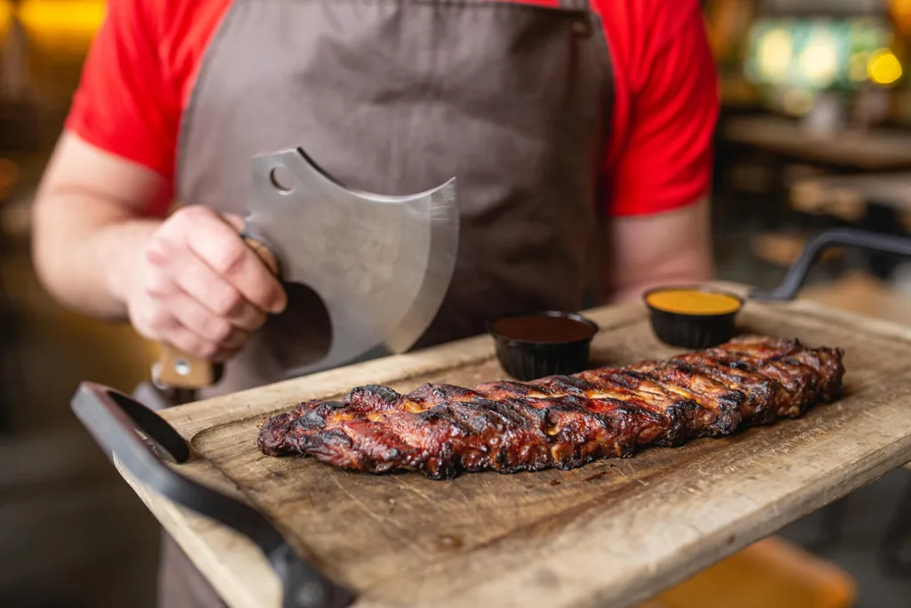 Соковиті свинячі реберця на дерев’яній дошці