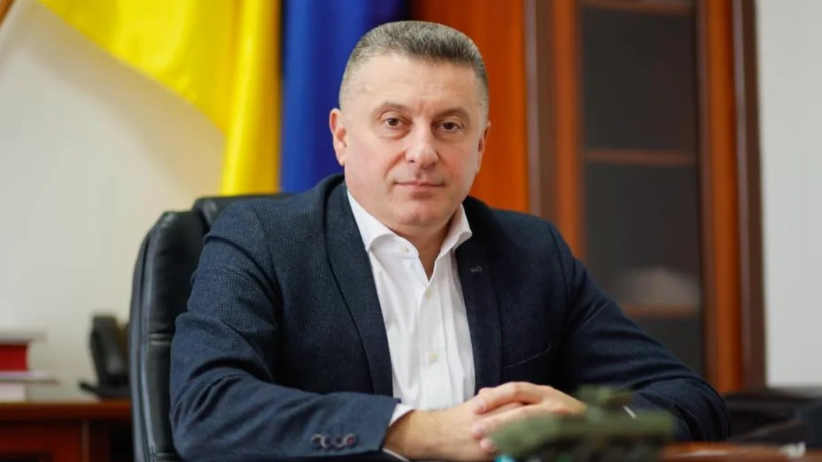 Чоловік сидить у кабінеті перед прапором України