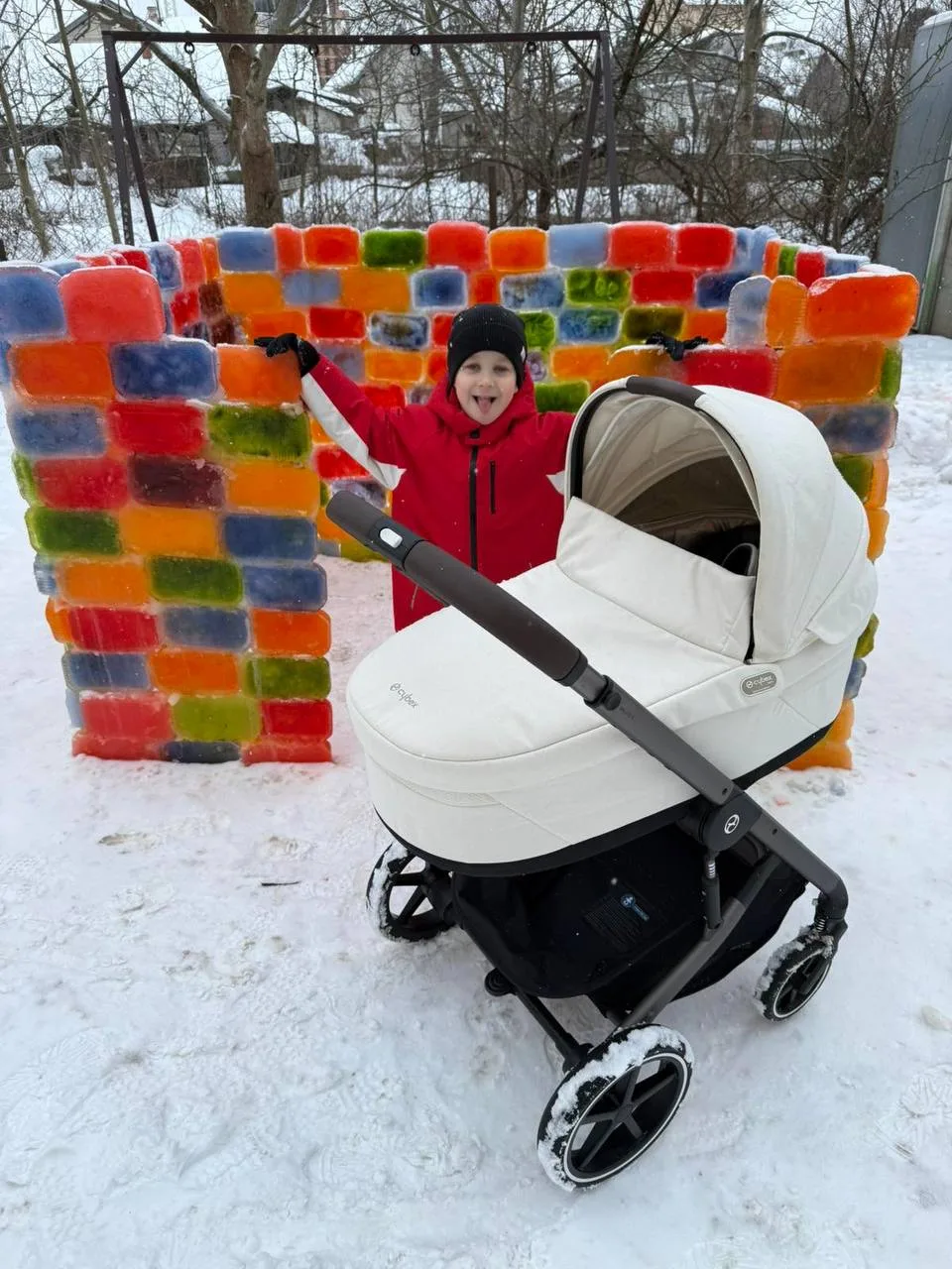 Дитина біля кольорової крижаної стіни взимку