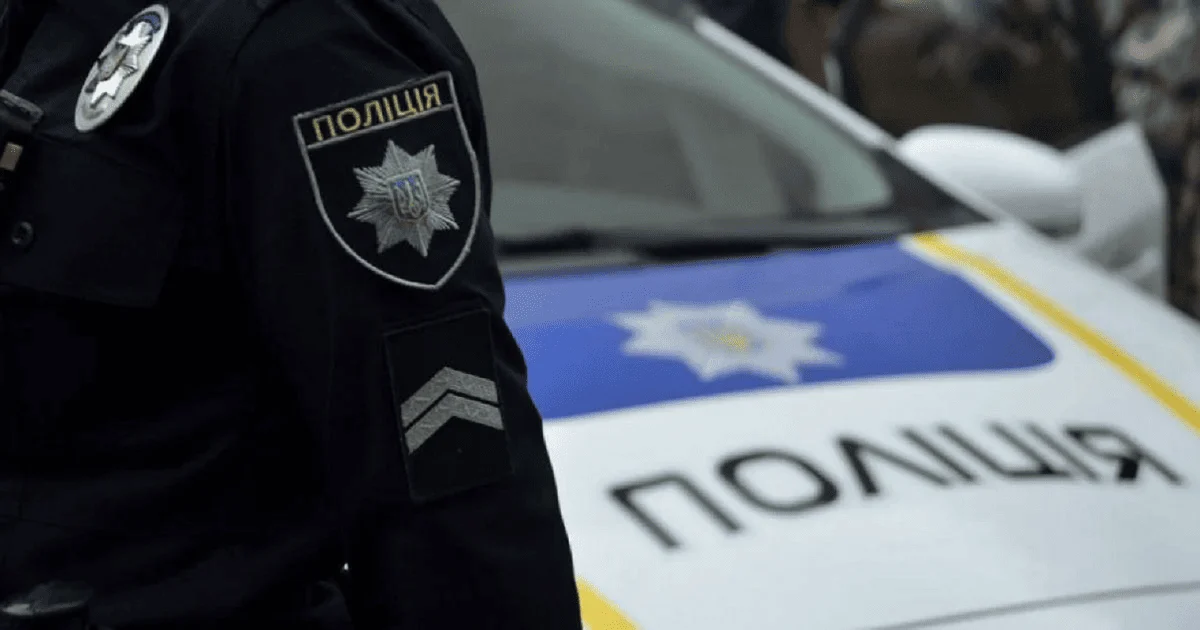 Поліцейський біля службового автомобіля поліції України