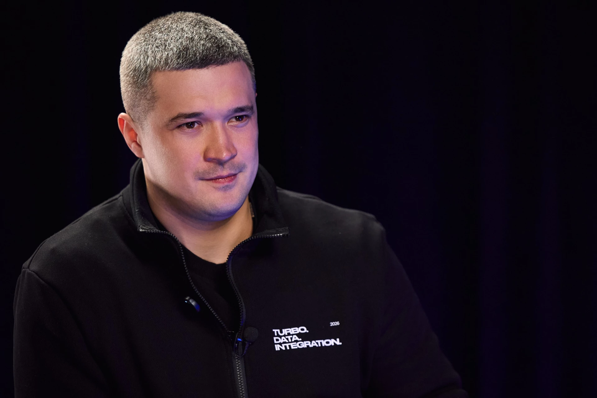 Чоловік у чорному светрі на темному фоні