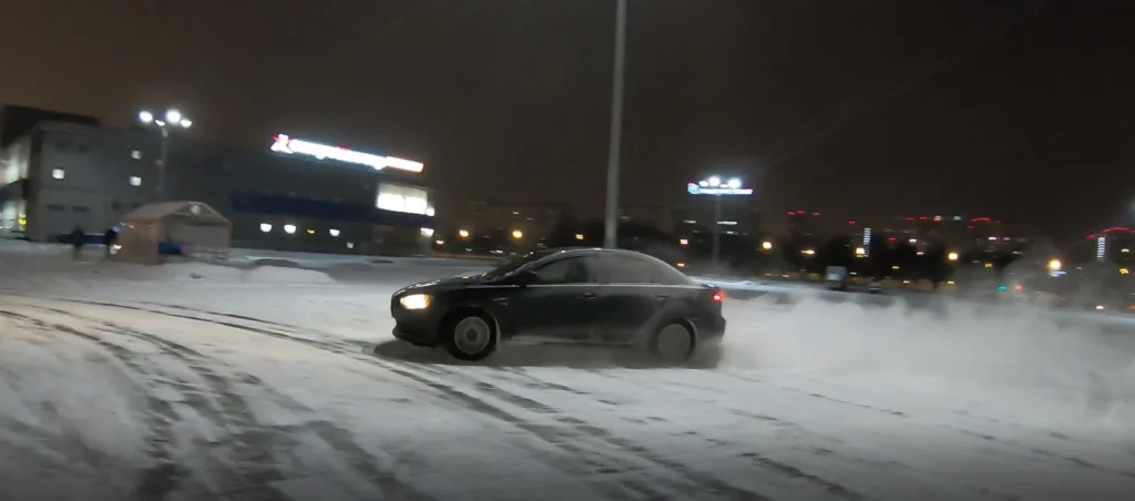 Автомобіль дрифтує на снігу вночі
