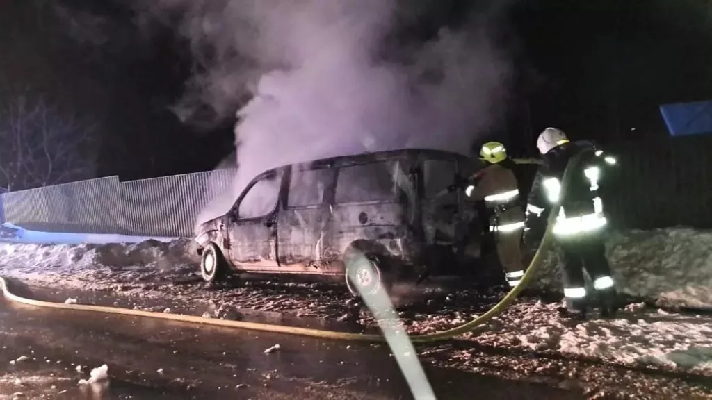 Пожежники гасять палаючий автомобіль уночі