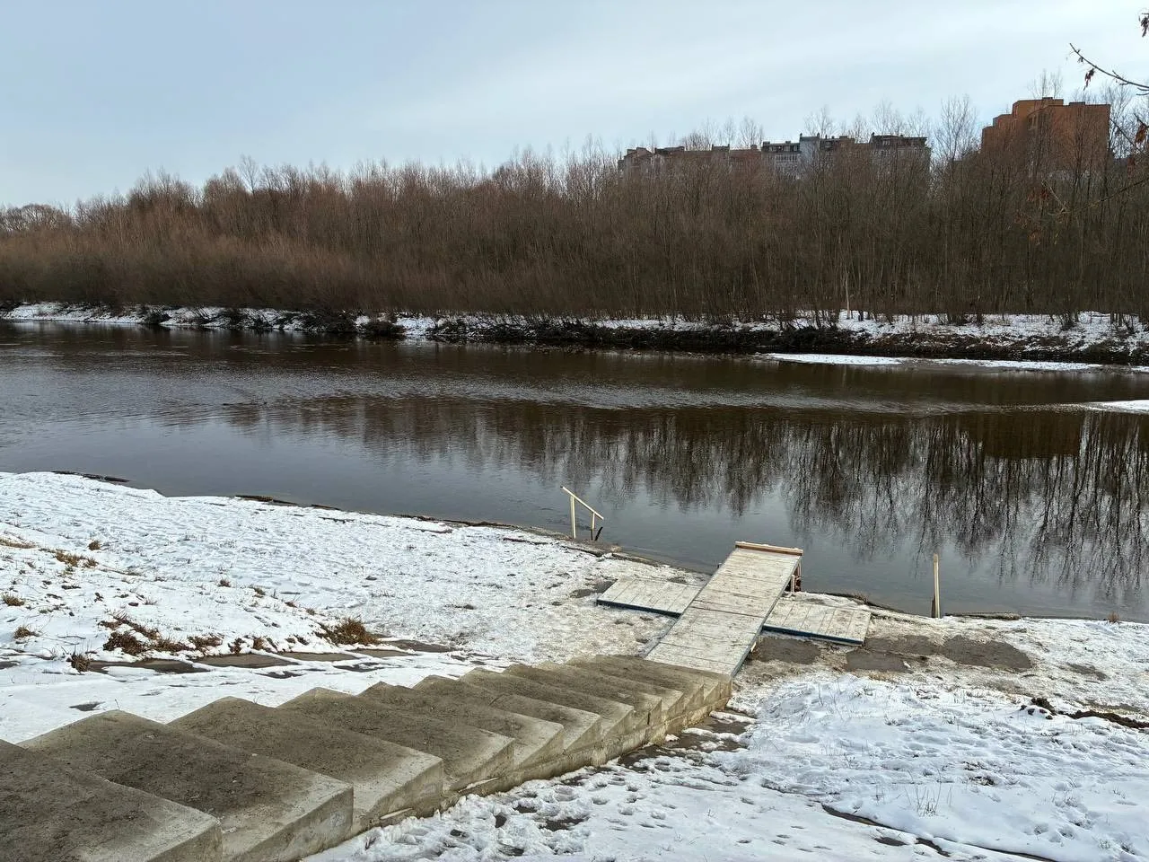 Зимовий вид на річку з пірсом і сходами