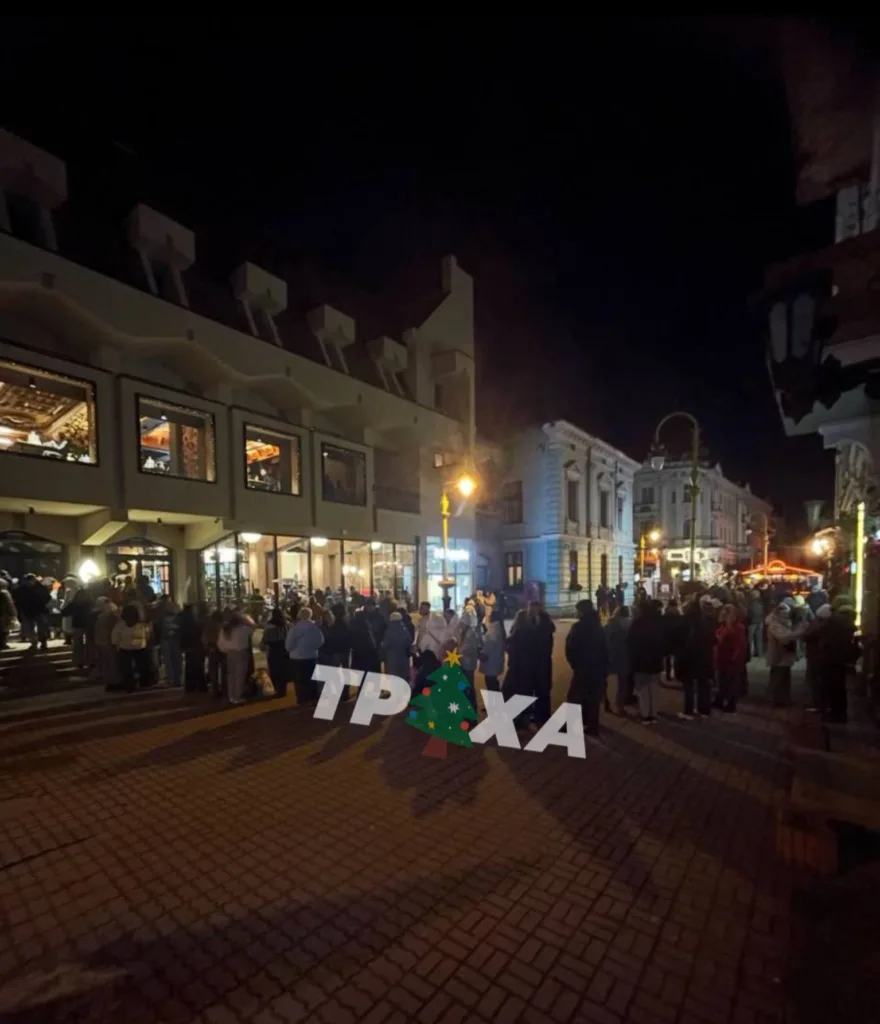 Натовп людей на вулиці вночі біля будівлі